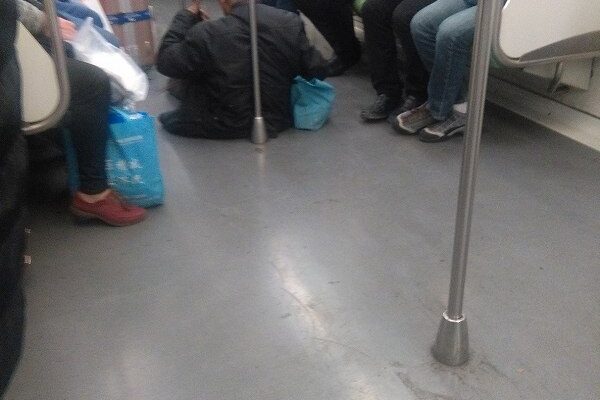 地下鉄車内の床に座って二胡を弾く老人